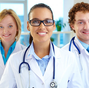 three healthcare professionals smiling at the camera